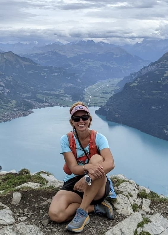 Liz Lucarelli, owner of Lucarelli Wellness sitting in a beautiful setting in Switzerland